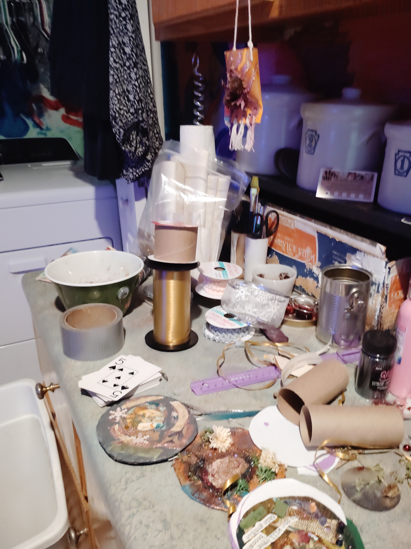 A Soul Cloth Sanctuary worktable with spools, ribbon, cards, bowls, and handmade pieces in progress