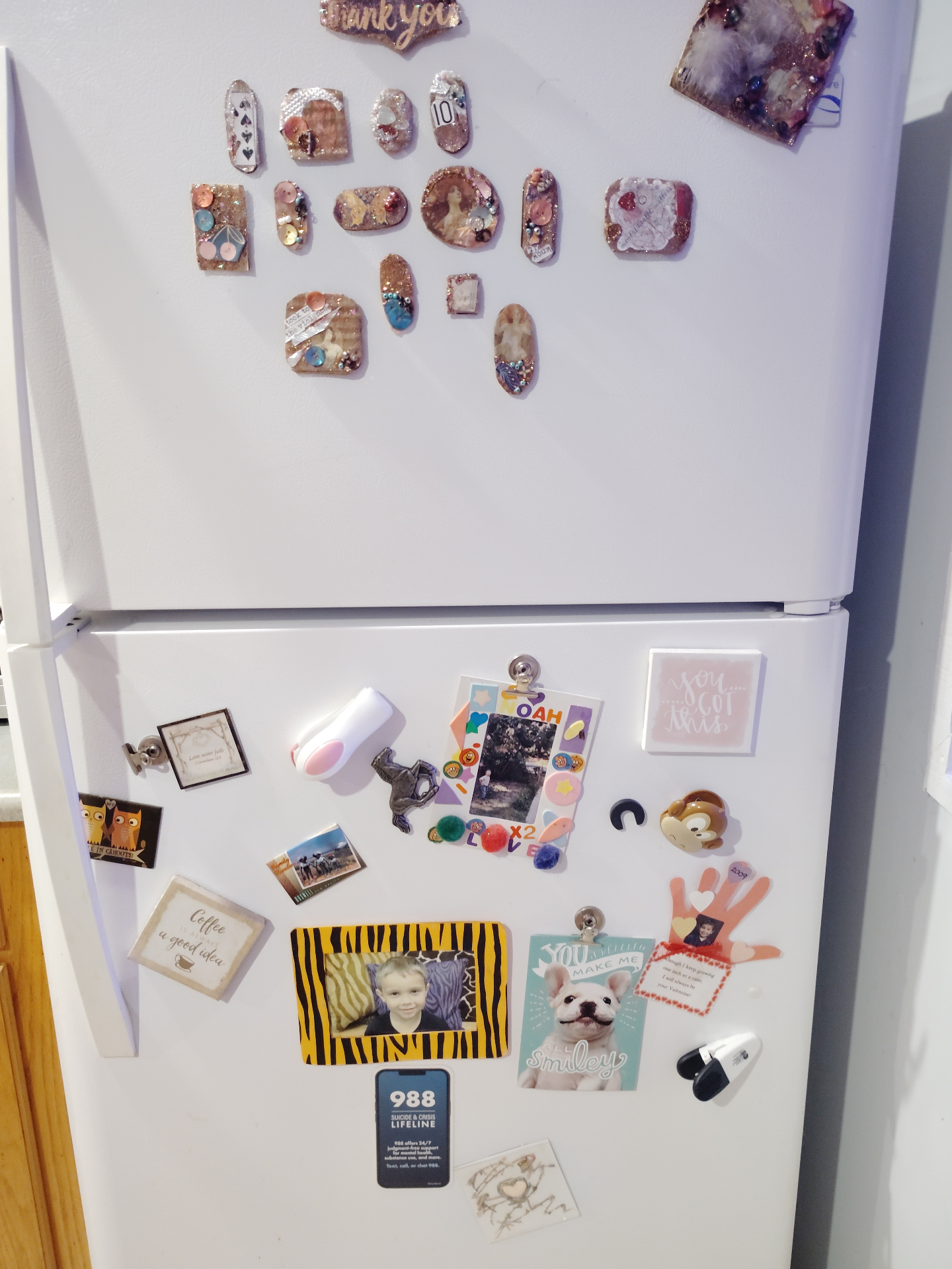 A white refrigerator at the Cat Nap Inn with handmade magnets displayed across the top door among family keepsakes and cheerful notes