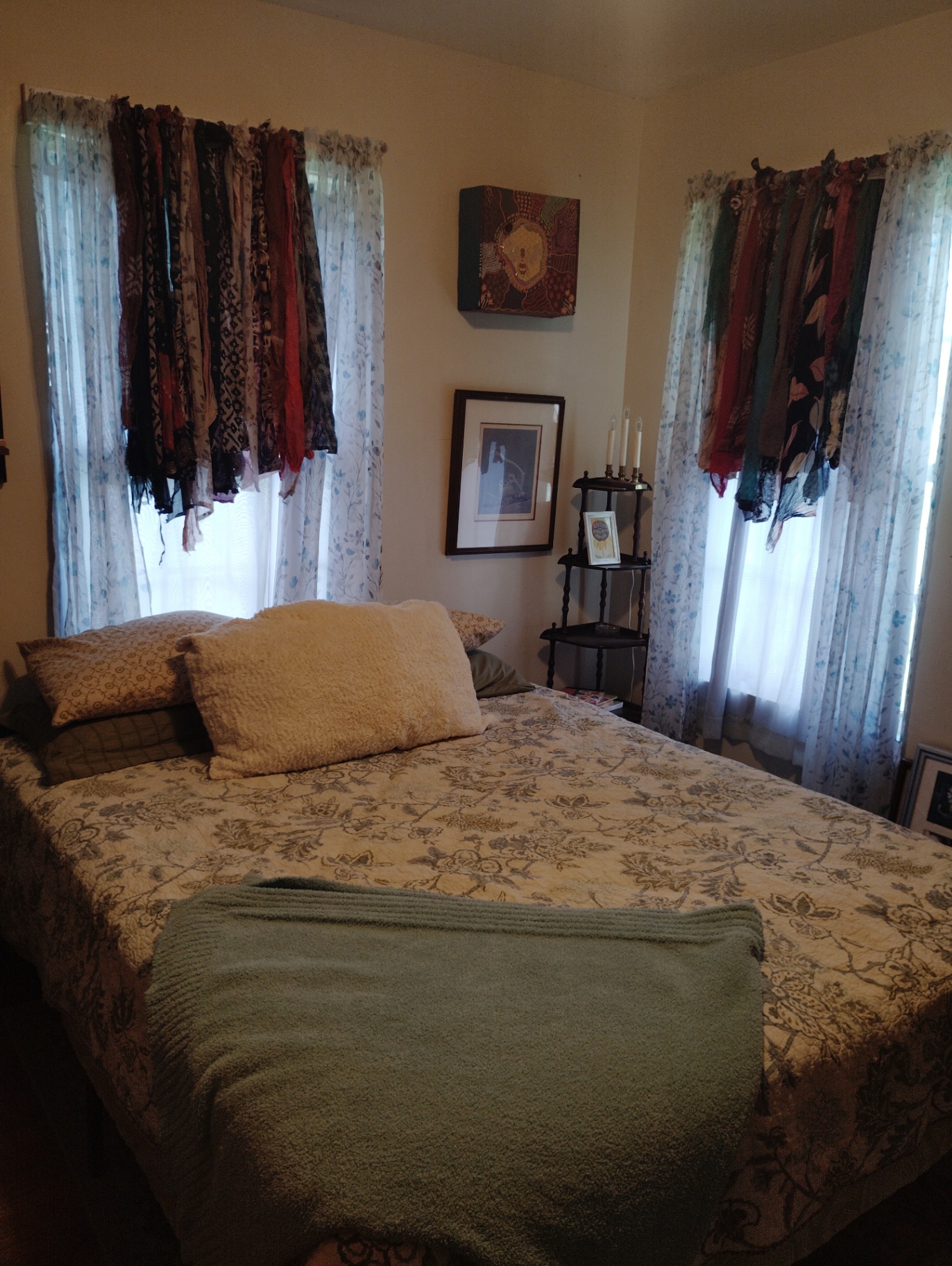 Weston's bedroom at the Cat Nap Inn with a neatly made bed, floral curtains, framed art, and a small corner shelf